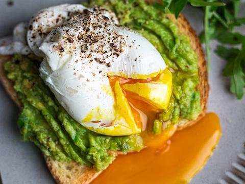 Poached egg with runny yolk on crispy avocado toast